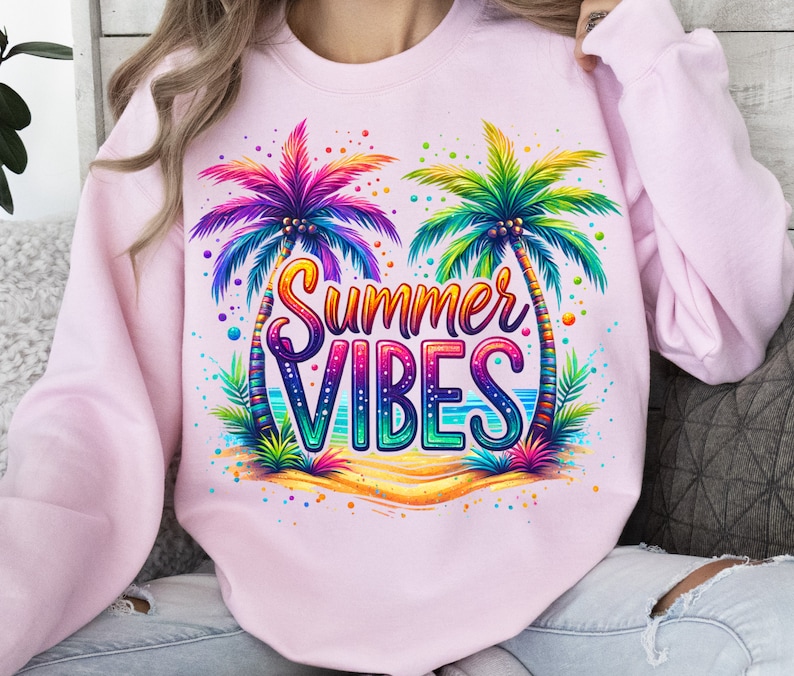 Peut inclure: Sweat-shirt rose avec un motif color&eacute; de deux palmiers et le texte "Summer Vibes".