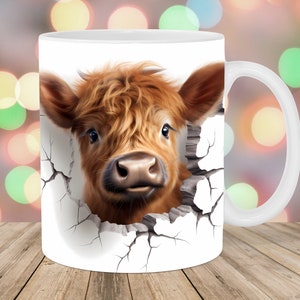 May include: White ceramic mug featuring a brown and white Highland cow peeking through a cracked wall design.
