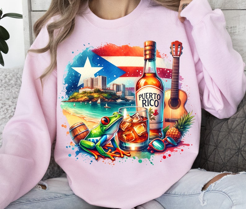 May include: A pink sweatshirt with a colourful design featuring a Puerto Rican flag, a bottle of rum labelled "Puerto Rico", a glass of rum, a green tree frog, a guitar, and a pineapple.