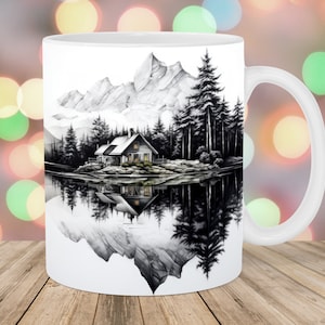 May include: White ceramic mug featuring a black and white illustration of a cabin in the woods reflected in a lake. The cabin has a pitched roof and windows with yellow light shining through. The trees are tall and slender, and the mountains in the background are snow-capped.