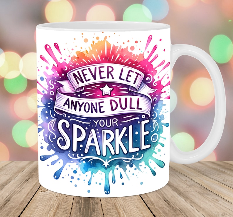 K&ouml;nnte beinhalten: Wei&szlig;e Keramik-Kaffeetasse mit einem farbenfrohen Aquarelldesign und dem Text "Lass niemals jemanden deinen Glanz tr&uuml;ben".