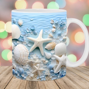 Puede incluir: Taza de cerámica blanca con un diseño de conchas marinas azul y blanco. La taza presenta una estrella de mar, conchas marinas y un patrón de olas oceánicas azules.