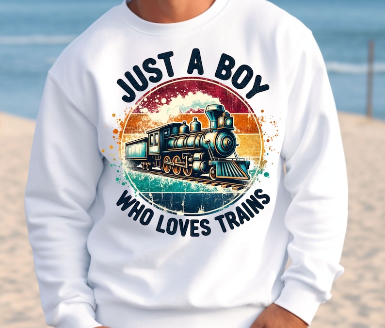 May include: White sweatshirt with a vintage-style graphic of a train and the text "Just a Boy Who Loves Trains".