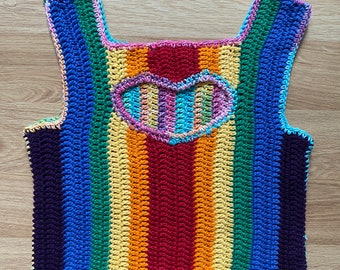 May include: A rainbow striped crochet top with a heart-shaped cutout in the front. The heart is crocheted in a multi-colored pattern.