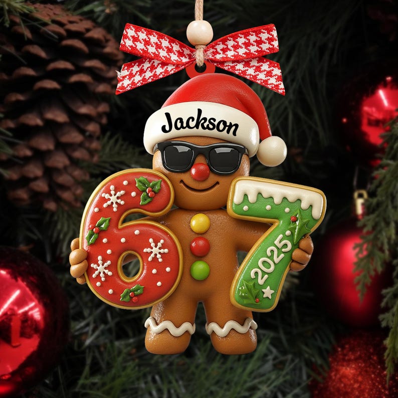 May include: A gingerbread man Christmas ornament wearing sunglasses and a Santa hat with the name "Jackson". The ornament holds the numbers "6" and "7" with the year "2025". A red and white bow is at the top.
