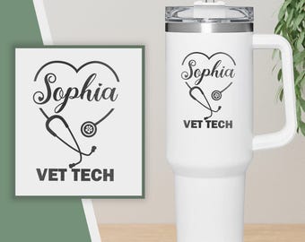 May include: A white tumbler with a handle and a clear lid. The tumbler features a black heart-shaped design with the name "Sophia", a stethoscope, and the words "VET TECH". A matching design is on a square card.