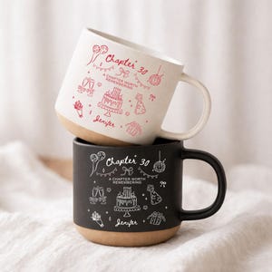 Puede incluir: Dos tazas de cerámica, una blanca y otra negra, apiladas. La taza blanca tiene ilustraciones y texto en rojo: "Chapter 30, A Chapter Worth Remembering, Jenifer." La taza negra tiene ilustraciones y texto en blanco: "Chapter 30, A Chapter Worth Remembering, Jenifer."