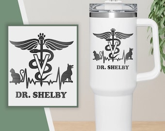 Pode incluir: Caneca de viagem branca com um gráfico preto e branco de um caduceu, um batimento cardíaco e o texto "DR. SHELBY".