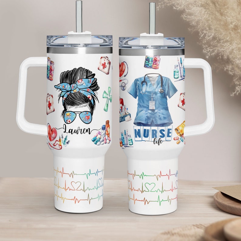 May include: White travel mug with a handle and a straw. One side features a nurse design with the name "Lauren", and the other side has a nurse uniform and the words "NURSE life". The bottom has a colorful heartbeat design.