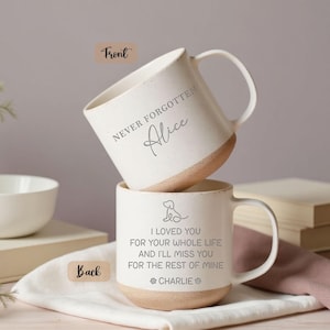 May include: Two stacked white ceramic mugs with a tan base. The top mug reads "NEVER FORGOTTEN Alice". The bottom mug has a dog illustration and the text "I LOVED YOU FOR YOUR WHOLE LIFE AND I'LL MISS YOU FOR THE REST OF MINE CHARLIE".