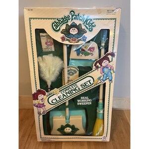 May include: A boxed Cabbage Patch Kids Complete Cleaning Set. The set includes a broom, dustpan, feather duster, and a small carpet cleaner. The box features illustrations of Cabbage Patch Kids and the text "Complete Cleaning Set" and "Real Working Sweeper".