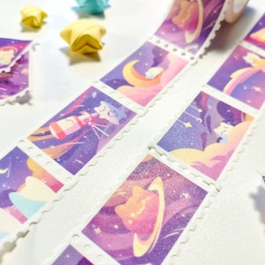 Pu&ograve; includere: Un rotolo di nastro washi con un motivo ripetitivo di personaggi dei cartoni animati colorati e stelle su uno sfondo viola e rosa. Il nastro ha un bordo bianco con una linea punteggiata attorno a ciascuna immagine.