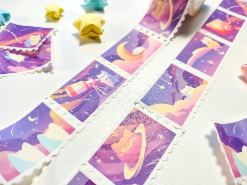 Pu&ograve; includere: Un rotolo di nastro washi con un motivo ripetitivo di personaggi dei cartoni animati colorati e stelle su uno sfondo viola e rosa. Il nastro ha un bordo bianco con una linea punteggiata attorno a ciascuna immagine.