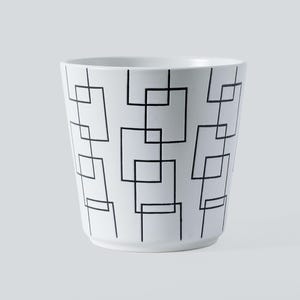 Op de afbeelding: Witte keramische bloempot met een herhalend zwart geometrisch vierkant patroon. De pot heeft een licht taps toelopende vorm en een gladde, glanzende afwerking. Deze pot is geschikt voor binnen of buiten en ideaal voor planten.