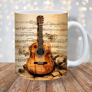 Może przedstawiać: Biały kubek ceramiczny z nadrukowanym brązowym akustycznym gitarą. Gitara jest otoczona nutami muzycznymi i vintage'owym tłem.