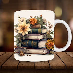May include: White ceramic mug featuring a stack of books adorned with floral arrangements. The books have green and gold covers, and the flowers are in shades of yellow, orange, and cream. The mug has a white handle and is set against a blurred background.
