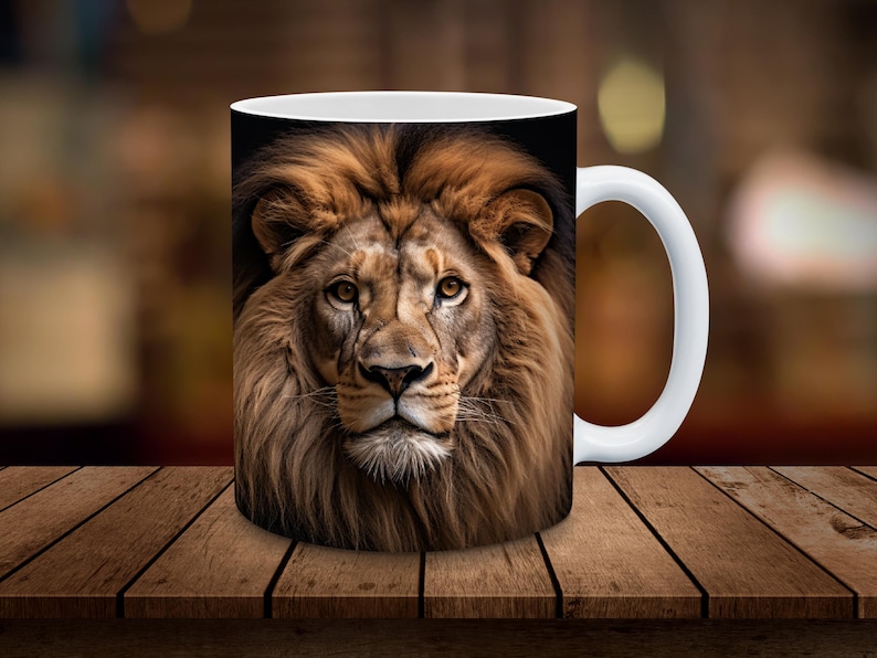 May include: White ceramic mug with a brown and black lion's face printed on it. The lion has a full mane and is looking directly at the viewer.
