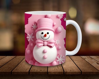 May include: A white ceramic mug with a pink snowman design. The snowman has a pink hat, a pink bow tie, and pink buttons. The background is pink with white snowflakes.
