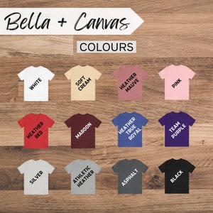 May include: A Bella + Canvas colour chart showing 12 different t-shirt colours. The colours are: White, Soft Cream, Heather Mauve, Pink, Heather Red, Maroon, Heather True Royal, Team Purple, Silver, Athletic Heather, Asphalt, and Black.