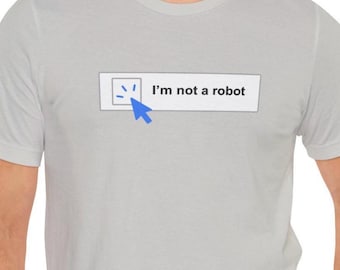 May include: Light gray t-shirt with a graphic that says "I'm not a robot." The graphic includes a blue cursor and a small box with a checkmark inside. The shirt is short-sleeved and has a crew neck.
