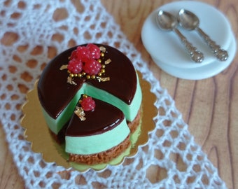 Tarta en miniatura de chocolate, pistacho y frambuesa para coleccionistas, casas de muñecas.