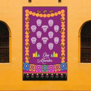 May include: A purple Día de Muertos banner featuring white sugar skulls, orange marigolds, and butterflies. The banner includes the text "Dia de Muertos" and colorful decorative elements at the bottom. The banner is displayed on a yellow wall.