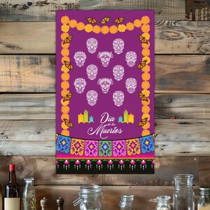May include: A purple Day of the Dead themed wall hanging with white sugar skulls, marigold flowers, and butterflies. The words "Dia de los Muertos" are written in white script. The bottom border has colorful papel picado designs.