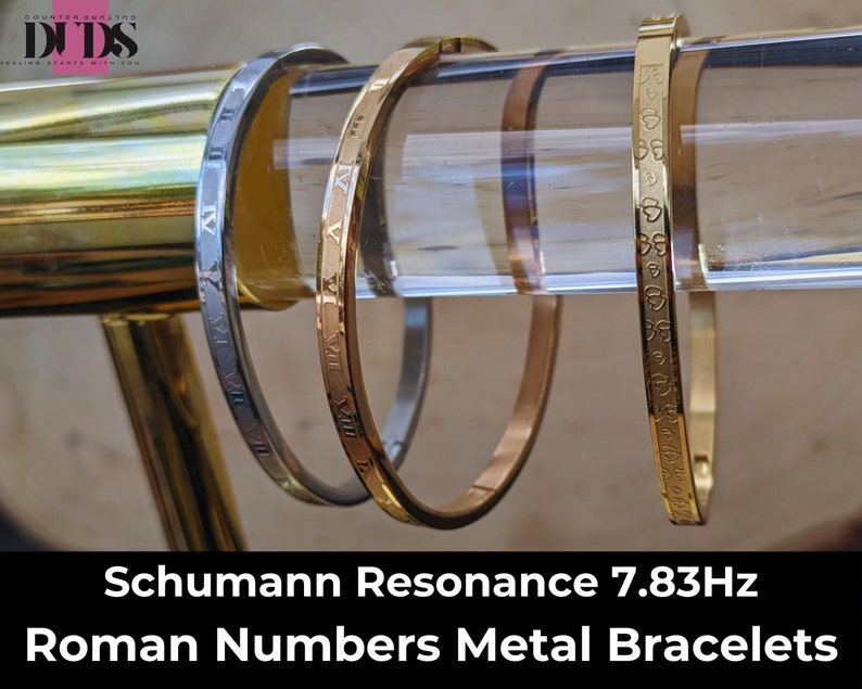 May include: Three metal bracelets with Roman numeral engravings. The bracelets are displayed on a clear acrylic stand. The bracelets are gold, silver, and rose gold in color. The text "Schumann Resonance 7.83Hz Roman Numbers Metal Bracelets" is displayed below the bracelets.