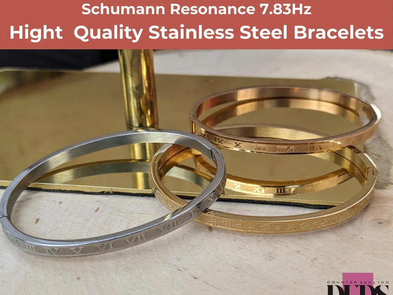 May include: Three stainless steel bracelets with Roman numeral engravings. The bracelets are stacked on top of each other. The top bracelet is rose gold, the middle bracelet is gold, and the bottom bracelet is silver. The text 'Schumann Resonance 7.83Hz' is at the top of the image. The text 'Hight Quality Stainless Steel Bracelets' is below the text 'Schumann Resonance 7.83Hz'.
