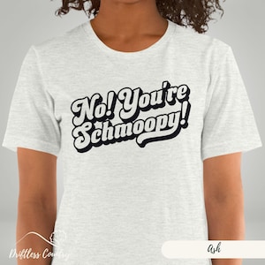 May include: A heather grey t-shirt with the text "No! You're Schmoopy!" in a retro font.