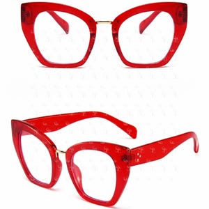 May include: Two pairs of red cat-eye glasses with clear lenses. The frames are a vibrant red with a gold-colored bridge. The glasses are displayed from two different angles, showcasing their shape and design.