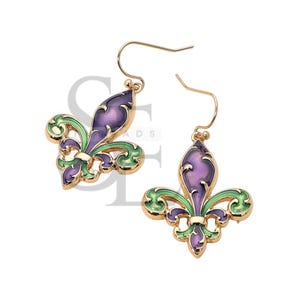 May include: A pair of gold-colored metal earrings featuring a fleur-de-lis design. The earrings have a purple center with green and gold accents. The earrings have a hook closure.