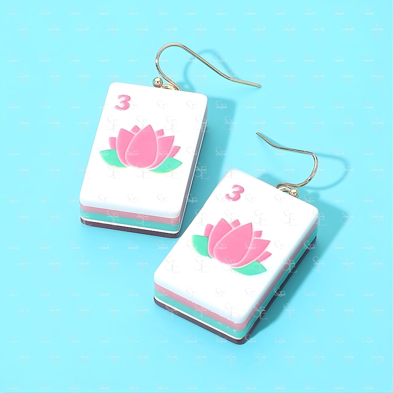 Mahjong tile earrings with pink lotus design on blue background