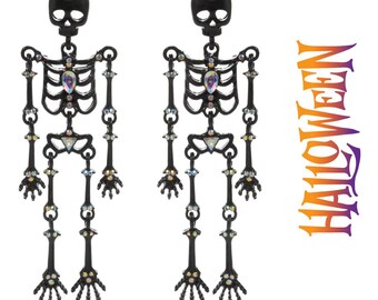 May include: A pair of black skeleton earrings with iridescent rhinestones. The earrings are dangling and feature a skeleton design with a skull at the top.
