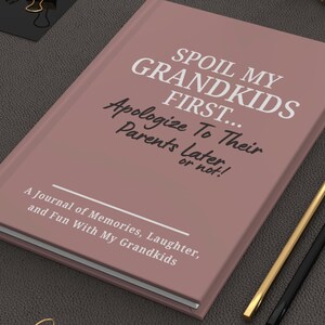 Peut inclure: Un journal mauve avec le texte "SPOIL MY GRANDKIDS FIRST... Apologize To Their Parents Later, or not!" et "A Journal of Memories, Laughter, and Fun With My Grandkids." Des crayons dor&eacute;s et noirs sont &agrave; c&ocirc;t&eacute; du journal.