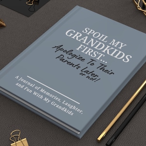 Peut inclure: Un journal gris avec le texte "SPOIL MY GRANDKIDS FIRST... Apologize To Their Parents Later or not !" et "A Journal of Memories, Laughter, and Fun With My Grandkids." Des crayons dor&eacute;s et noirs sont &agrave; c&ocirc;t&eacute; du journal.