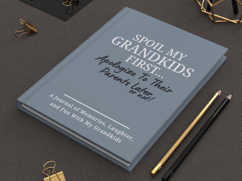 Peut inclure: Un journal gris avec le texte "SPOIL MY GRANDKIDS FIRST... Apologize To Their Parents Later or not !" et "A Journal of Memories, Laughter, and Fun With My Grandkids." Des crayons dor&eacute;s et noirs sont &agrave; c&ocirc;t&eacute; du journal.