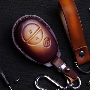 May include: A white ceramic mug with a black handle and the text "But First, Coffee" in a black, bold font. The mug is on a white surface.