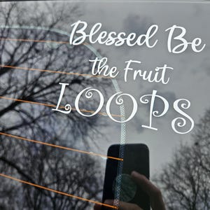May include: A white vinyl sticker on a car window that reads "Blessed Be the Fruit Loops".
