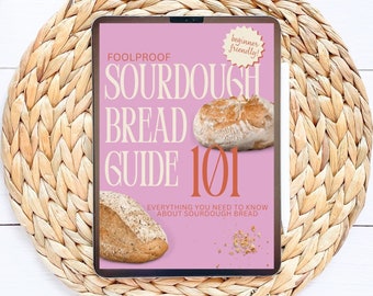 Może przedstawiać: Różowy tablet cyfrowy z okładką, na której widnieje napis "Foolproof Sourdough Bread Guide 101" z naklejką "przyjazny dla początkujących". Okładka przedstawia dwa bochenki chleba na zakwasie.