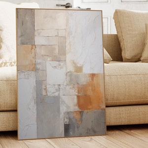 May include: Abstract art print with a geometric design in shades of beige, gray, and brown. The print is framed in a thin, gold frame.