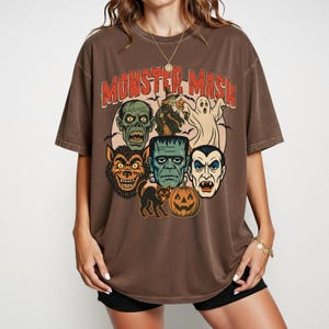 Espresso Comfort Colors Monster Mash Halloween shirt with Frankenstein, Dracula, ghost, witch, and pumpkin retro horror design on a cinnamon-colored oversized tee.