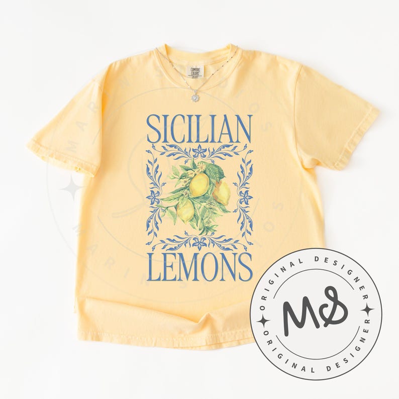 May include: Yellow t-shirt with the words "SICILIAN LEMONS" in blue, framed by a blue floral design. The graphic includes a cluster of lemons. A circular logo with "ORIGINAL DESIGNER" and "MS" is on the lower right.