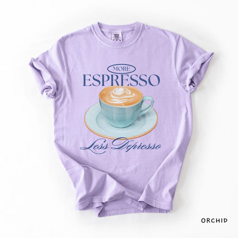 A flat lay of an Orchid Comfort Colors shirt with a design featuring an espresso and the phrase More Espresso Less Depresso.