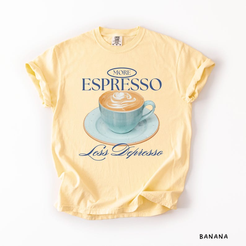 A flat lay of Butter Comfort Colors shirt with a design featuring an espresso and the phrase More Espresso Less Depresso.