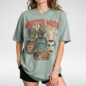 Bay Comfort Colors Monster Mash Halloween shirt with Frankenstein, Dracula, ghost, witch, and pumpkin retro horror design on a cinnamon-colored oversized tee.