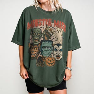 Blue Spruce Comfort Colors Monster Mash Halloween shirt with Frankenstein, Dracula, ghost, witch, and pumpkin retro horror design on a cinnamon-colored oversized tee.