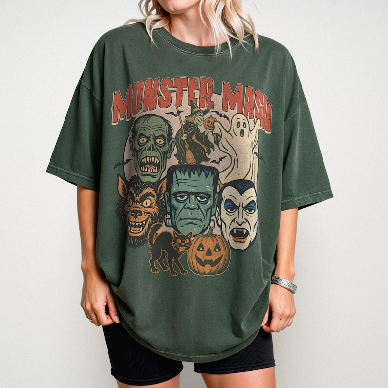 Blue Spruce Comfort Colors Monster Mash Halloween shirt with Frankenstein, Dracula, ghost, witch, and pumpkin retro horror design on a cinnamon-colored oversized tee.