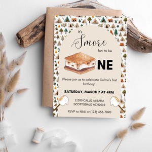 May include: A birthday invitation with a camping theme. The invitation features a watercolor illustration of a s'more and text that reads "It's S'more fun to be ONE." The invitation includes event details.