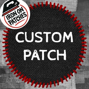 May include: A custom patch with the words "CUSTOM PATCH" in white block letters on a black denim-like background. The patch has a red stitched border. A circular logo with "IRON ON PATCHES" is in the upper left corner.
